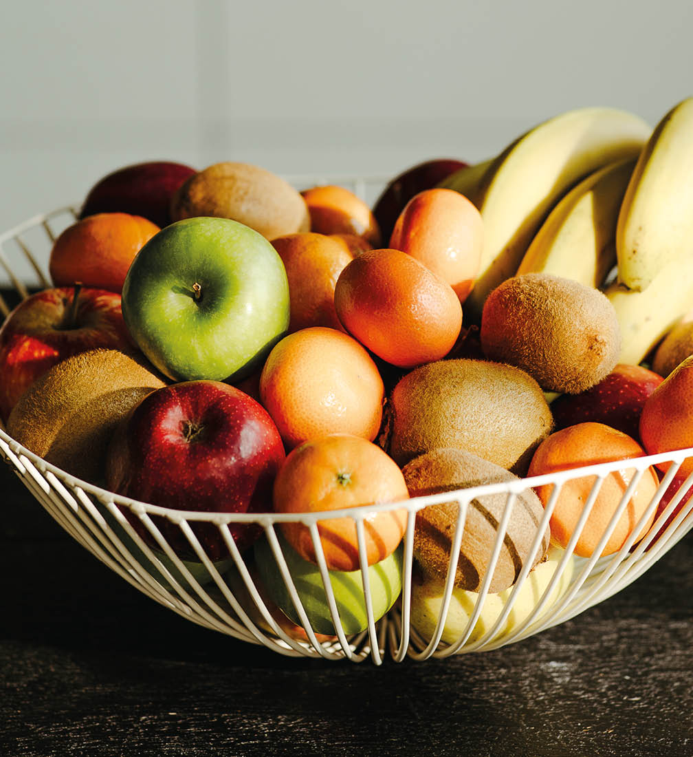 A bowl of fruit on a table, including bananas, apples, and oranges. AI generated content