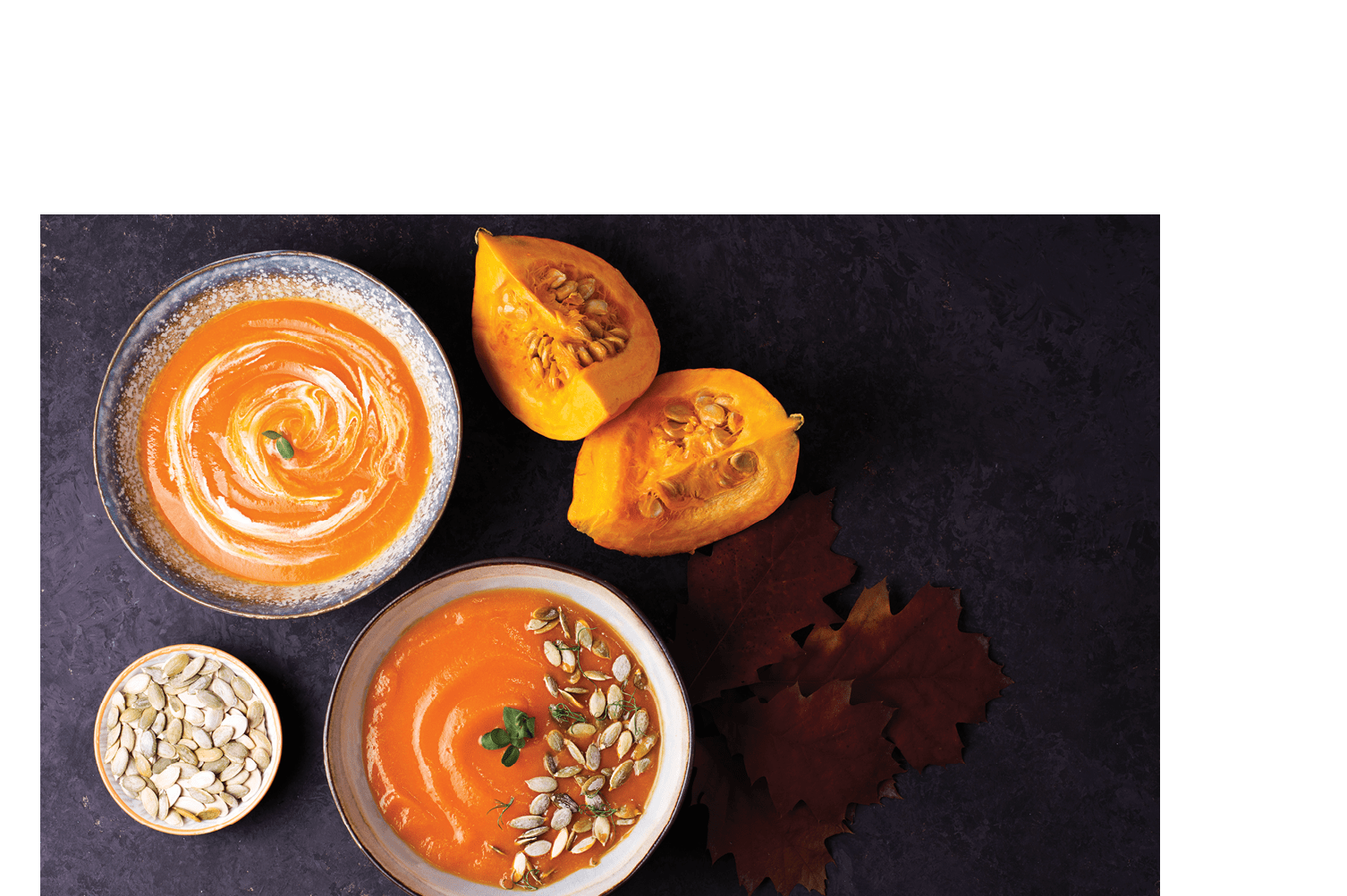Thanksgiving vegetarian pureed soup, pumpkin cream soup in a bowl on a dark background with croutons, top view.