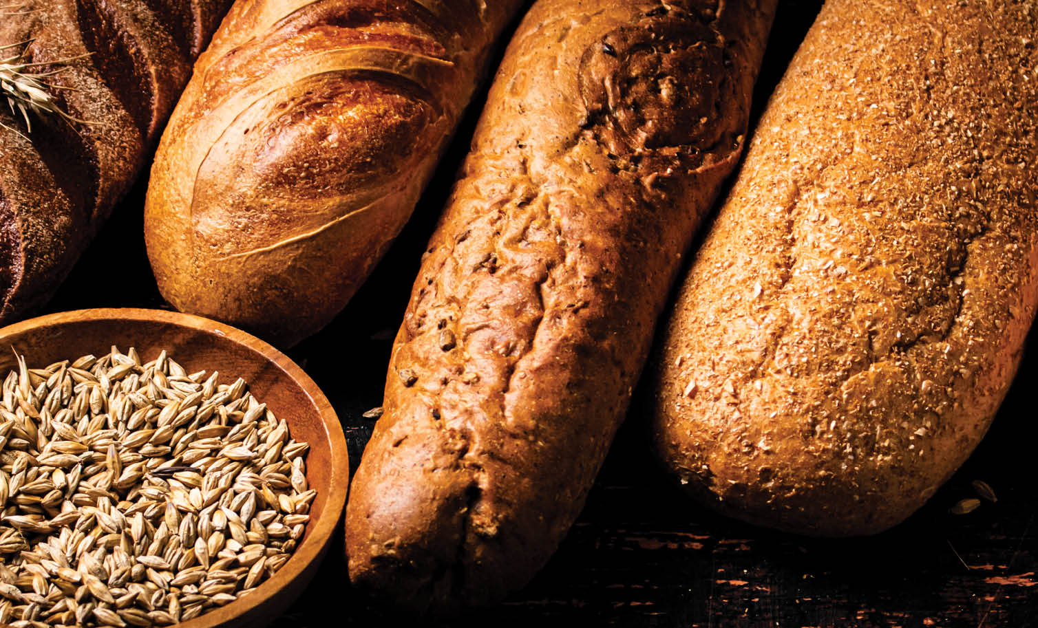 Various bread with grain in a bowl on the table. Against a dark background. High quality photo
