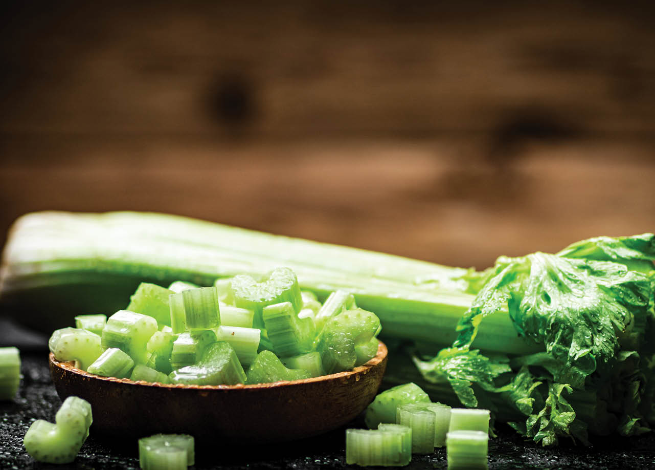 A plate of celery slices. On a wooden background. High quality photo