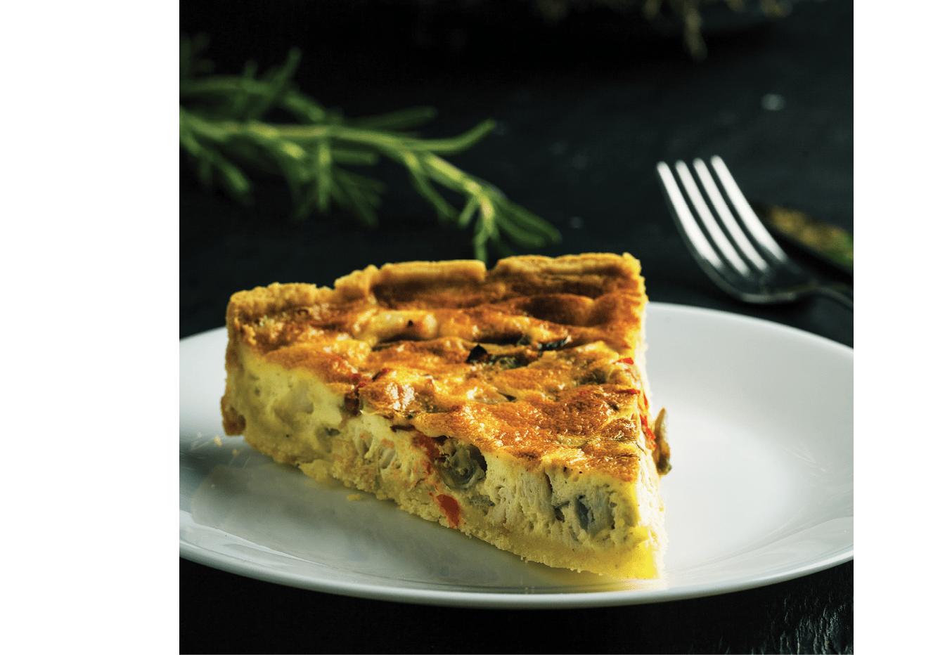 Delicious quiche on a plate on a dark background 