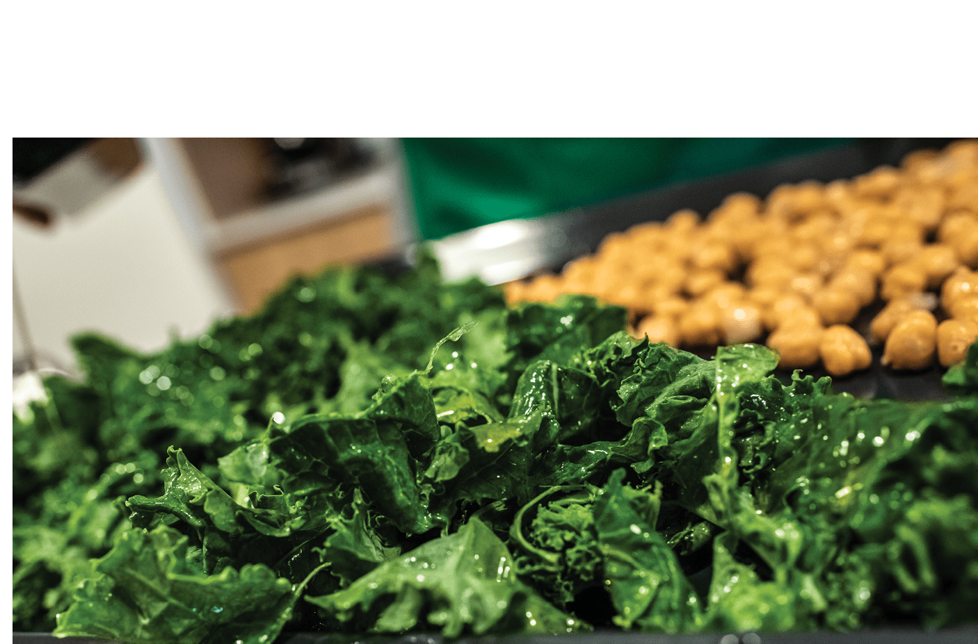 Chef preparing a dish of kale and chickpeas.