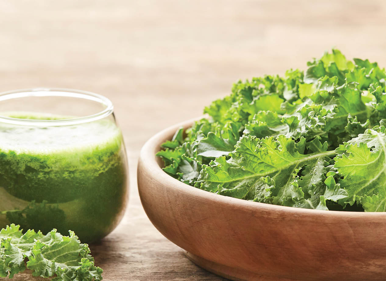 Healthy green kale smoothie with kale salad on wooden board