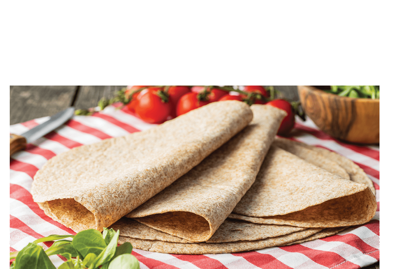 Whole grain tortilla wraps on checkered napkin.