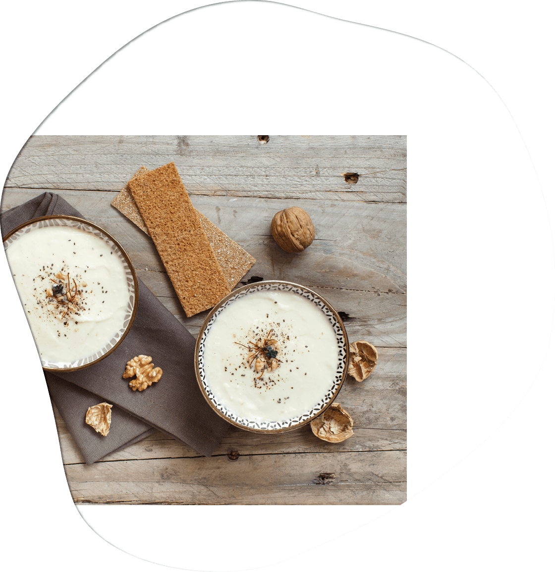 Creamy cauliflower soup in a bowl on a wooden table top view