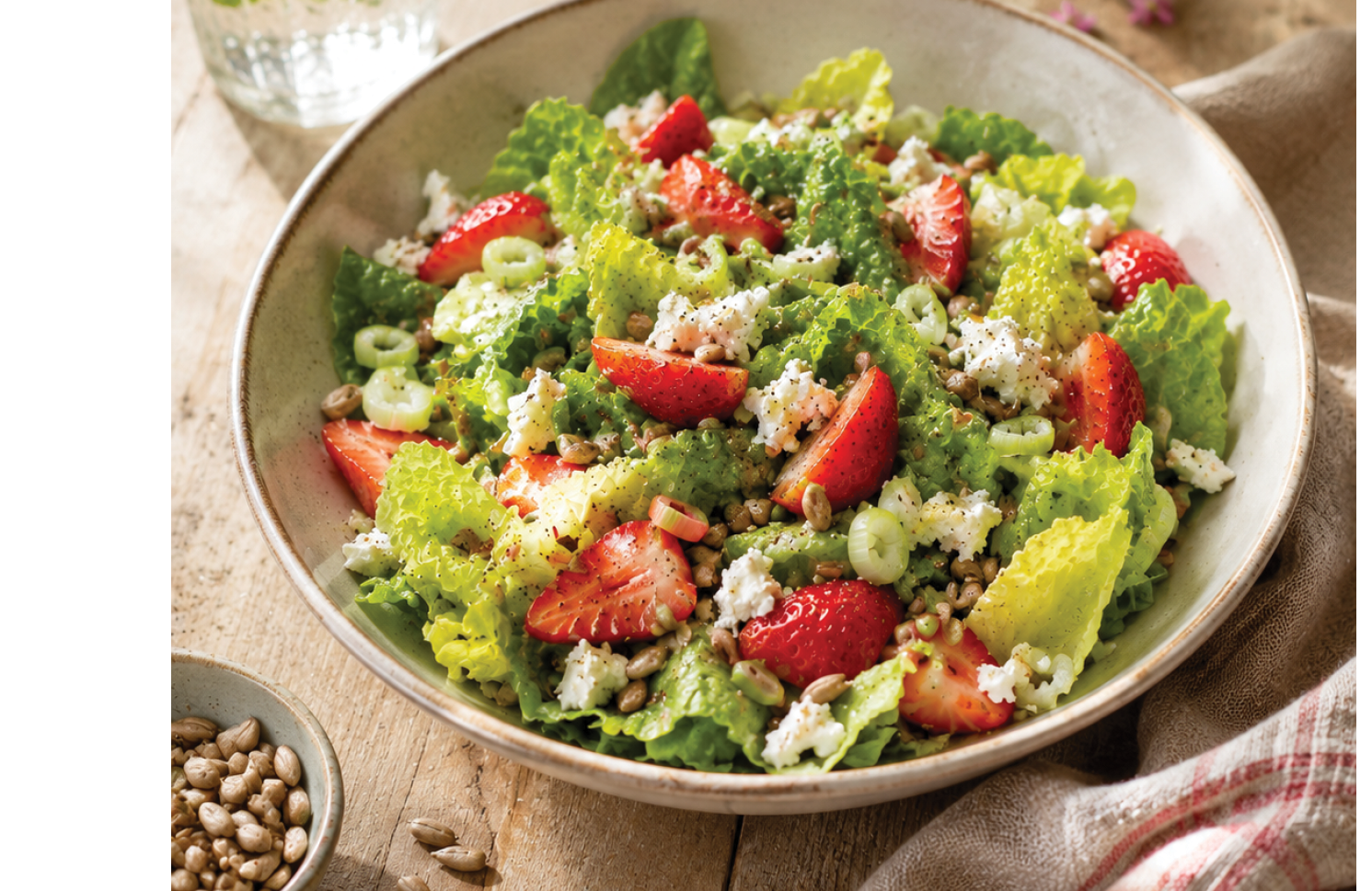 A bowl of salad with strawberries and lettuce. Description generated by AI