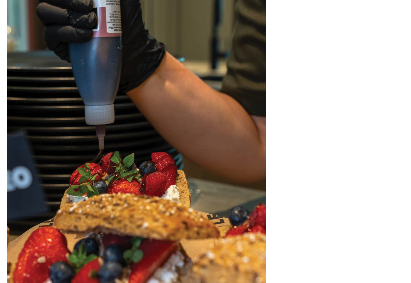 A person is pouring a sauce on a plate of food. Description generated by AI