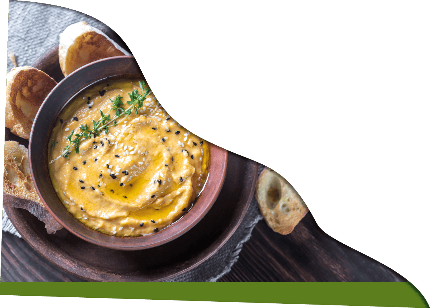 Bowl of pumpkin hummus with slices of toasted bread