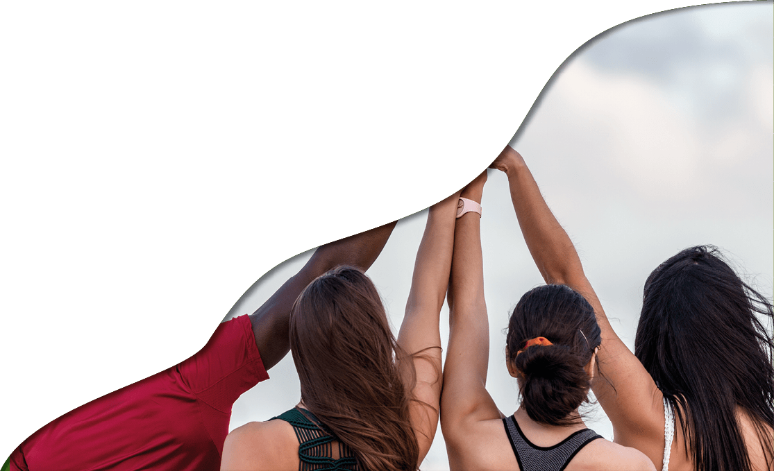 Back view of unrecognizable black man holding and raising arms with girlfriends against cloudy sky on beach on Lanzarote island, Spain
