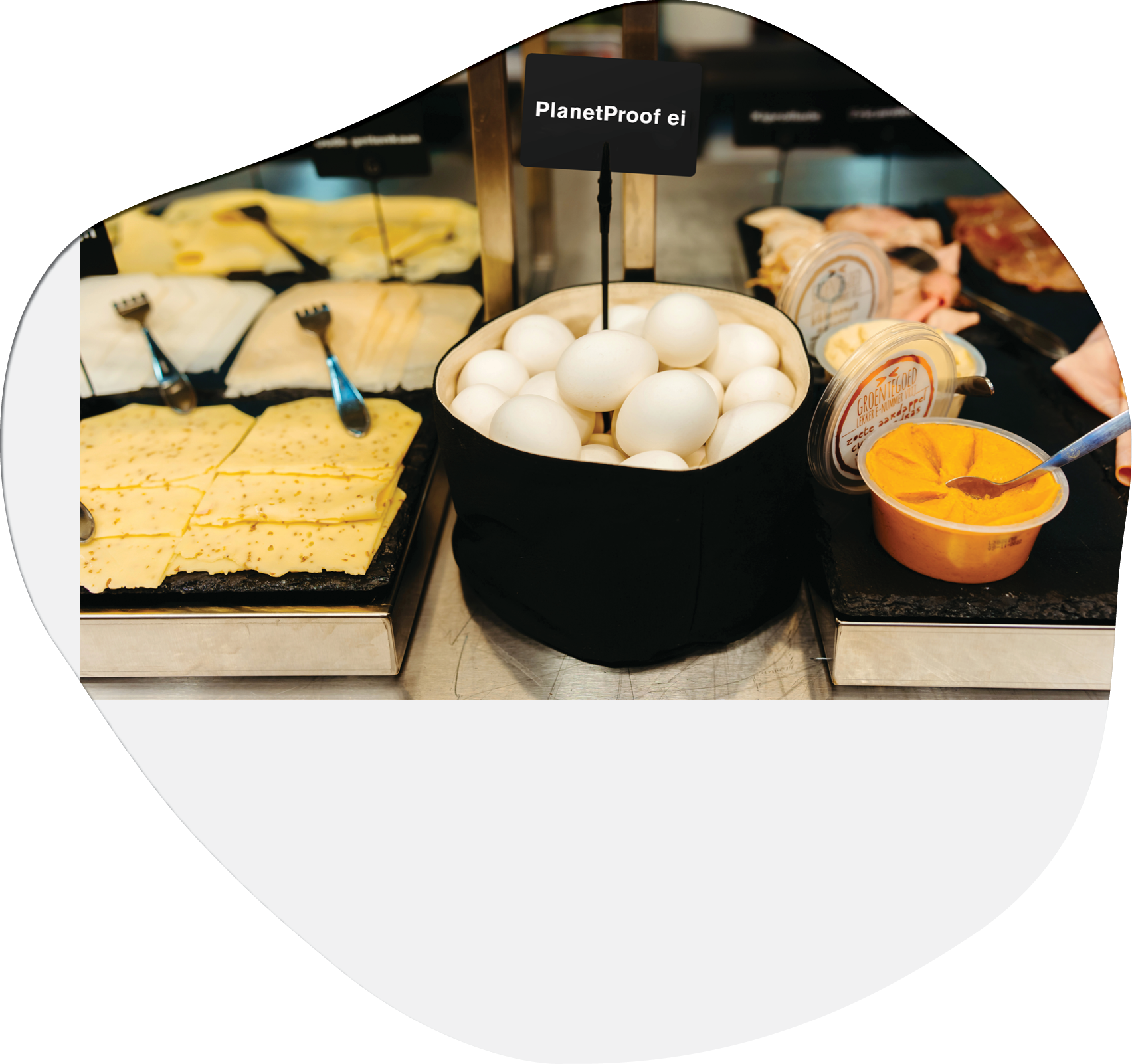 A variety of foods are displayed on a table, including eggs, meat, and cheese. There are also forks and spoons available for serving the food. AI generated content