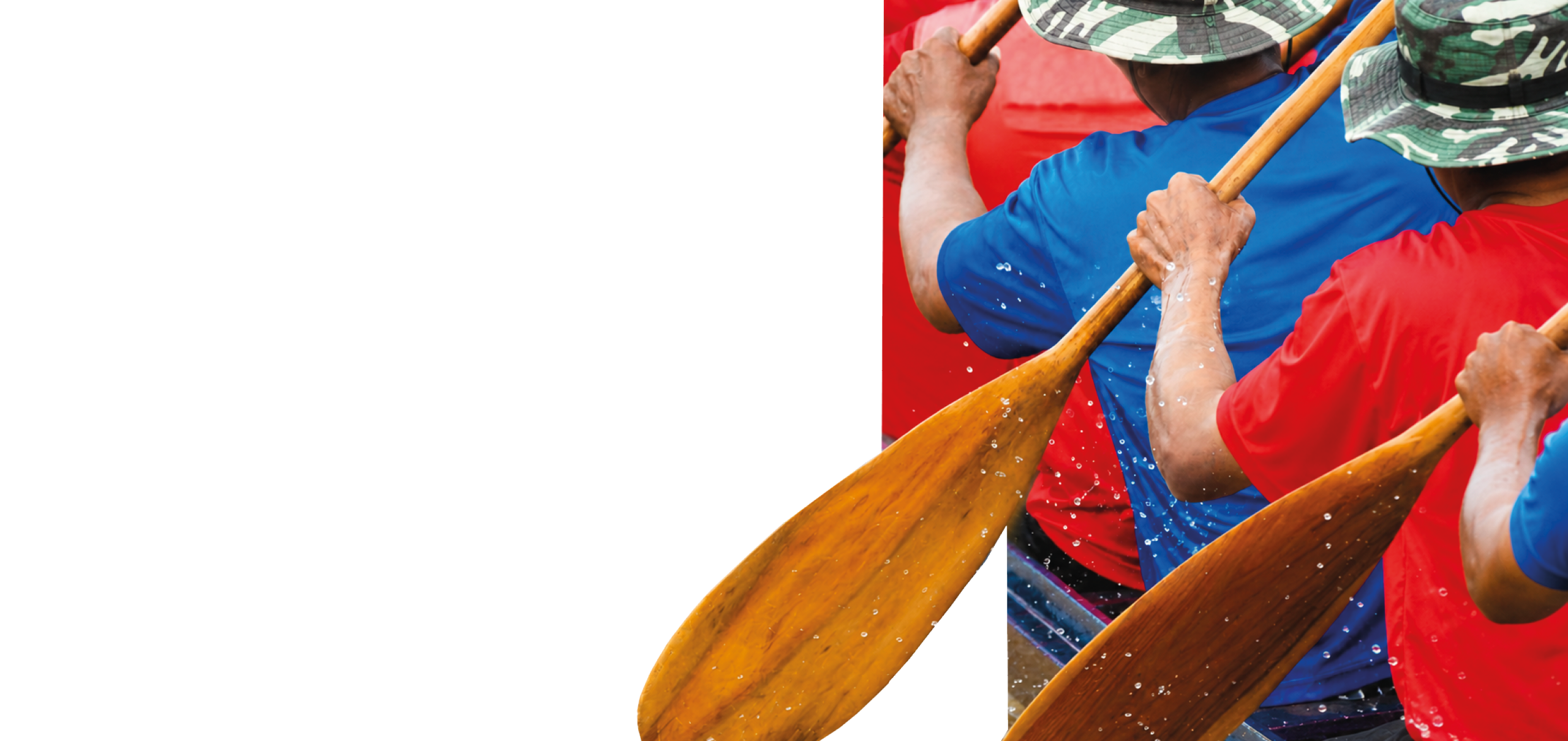 A group of people wearing red shirts and holding paddles. Description generated by AI