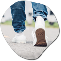 Close up woman wear jean and white sneaker walking forward on highway road in sunny day,Alone travel or solo traveler concept.